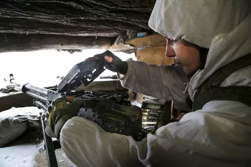 A serviceman checks his machine-gun in a shelter on the territory controlled by pro-Russian militants at frontline with Ukrainian government forces in Slavyanoserbsk, Luhansk region, eastern Ukraine, Tuesday, Jan. 25, 2022. Ukraine's leaders sought to reassure the nation that a feared invasion from neighboring Russia was not imminent, even as they acknowledged the threat is real and prepared to accept a shipment of American military equipment Tuesday to shore up their defenses. (AP Photo/Alexei 
