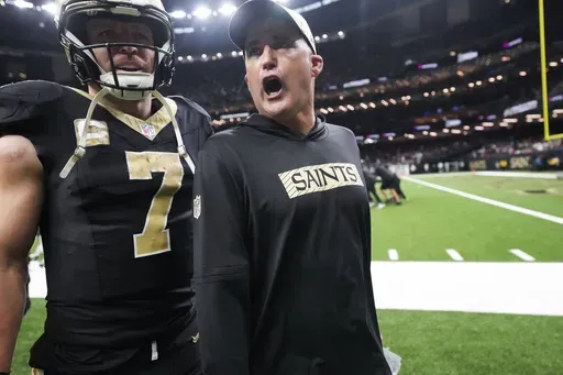New Orleans Saints interim head coach Darren Rizzi walks off the field with tight end Taysom Hill (7) at the end of the first half of an NFL football game against the Atlanta Falcons in New Orleans, Sunday, Nov. 10, 2024. The Saints won 20-17. (AP Photo/Gerald Herbert)