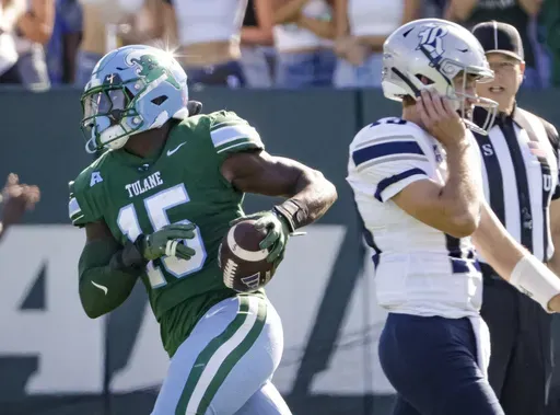 Tulane linebacker Sam Howard (15) trots past Rice quarterback E.J. Warner (13) after recovering a fumble during the first half of an NCAA football game at Yulman Stadium in New Orleans, Saturday, Oct. 19, 2024. (Scott Threlkeld/The Times-Picayune/The New Orleans Advocate via AP)