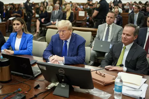 Former President Donald Trump, center, flanked by his defense attorneys, Alina Habba, left, and Chris Kiss, waits for the continuation of his civil business fraud trial at New York Supreme Court, Oct. 25, 2023, in New York. Trump's testimony on Monday will produce a rare spectacle of a former president being summoned to the stand as a trial witness. But Trump has actually had ample experience fielding questions from lawyers. His rhetorical style during years of depositions before becoming presid