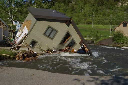 A house sits in Rock Creek after floodwaters washed away a road and a bridge in Red Lodge, Mont., on June 15, 2022. As cleanup from historic floods at Yellowstone National Park grinds on, climate experts and meteorologists say the gap between the destruction in the area and what was forecast underscores a troublesome trend tied to climate change: Modeling programs used to predict storms aren't keeping up with increasingly extreme weather. (AP Photo/David Goldman, File)