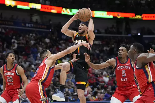 Phoenix Suns guard Devin Booker (1) goes to the basket between New Orleans Pelicans guard CJ McCollum (3) and forward Herbert Jones (5) in the second half of an NBA basketball game in New Orleans, Monday, April 1, 2024. The Suns won 124-111. (AP Photo/Gerald Herbert)
