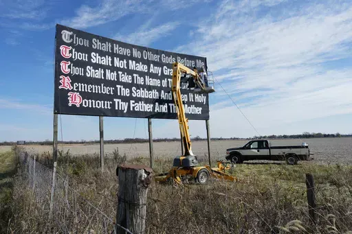 Workers repaint a Ten Commandments billboard off of Interstate 71 on Election Day near Chenoweth, Ohio, Tuesday, Nov. 7, 2023. Louisiana could soon become the first state to require that the Ten Commandments be displayed in every public school classroom — in another expansion of religion into day to day life by a Republican-dominated legislature. (AP Photo/Carolyn Kaster, File)