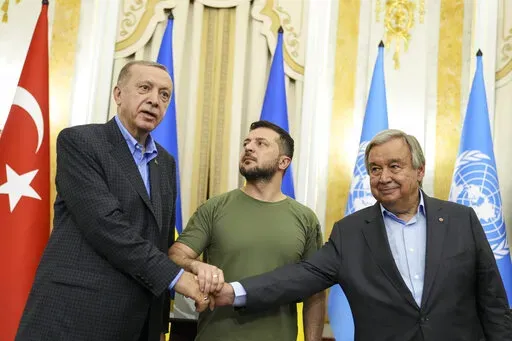 Ukrainian President Volodymyr Zelenskyy, center, Turkish President Recep Tayyip Erdogan, left, and United Nations Secretary General Antonio Guterres shake hands after their meeting in Lviv, Ukraine, Thursday, Aug. 18, 2022. (AP Photo/Evgeniy Maloletka)