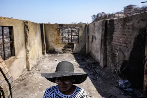 Aminta Guerra stands inside what is left of her charred home after a deadly forest fire affected the El Olivar neighborhood of Vina del Mar, Chile, Monday, Feb. 5, 2024. (AP Photo/Esteban Felix)