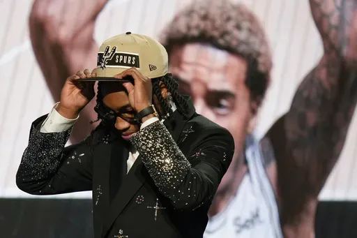Rob Dillingham, right, dons a San Antonio Spurs hat after being selected by the Spurs during the first round of the NBA basketball draft, Wednesday, June 26, 2024, in New York. (AP Photo/Julia Nikhinson)