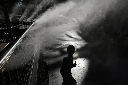 A child keeps cool beneath misters along the Las Vegas Strip, Friday, June 16, 2017, in Las Vegas. Pediatricians suggest keeping your child hydrated and avoiding prolonged sun exposure to keep heat illness at bay. (AP Photo/John Locher, File)
