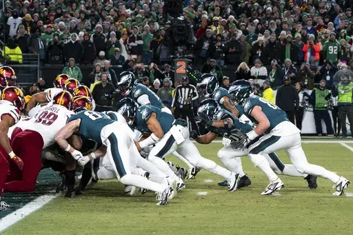 Philadelphia Eagles quarterback Jalen Hurts, center, and teammates run the tush push play during the NFL championship playoff football game against the Washington Commanders, Sunday, Jan. 26, 2025, in Philadelphia. (AP Photo/Chris Szagola, FIle)