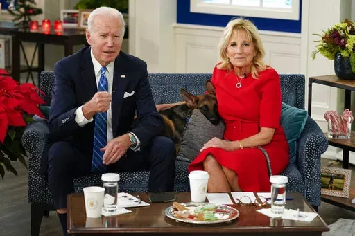 President Joe Biden, first lady Jill Biden and their new dog Commander, a purebred German shepherd puppy, meet virtually with service members around the world, Saturday, Dec. 25, 2021, in the South Court Auditorium on the White House campus in Washington, to thank them for their service and wish them a Merry Christmas. (AP Photo/Carolyn Kaster)