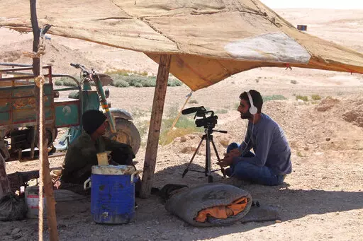 This photo provided by the family of Mohammed-Nour Mattar, shows Syrian journalist Mohammed Nour Matar interviewing a man while filming a documentary about primitive ways of refining oil, in the Raqqa countryside of Syria, August 2013. Matar is among thousands of people believed to have been seized by the Islamic State, the extremist group that seized large parts of Syria and Iraq in 2014 where it set up a so-called Islamic Caliphate and brutalized the population for years. Three years after the