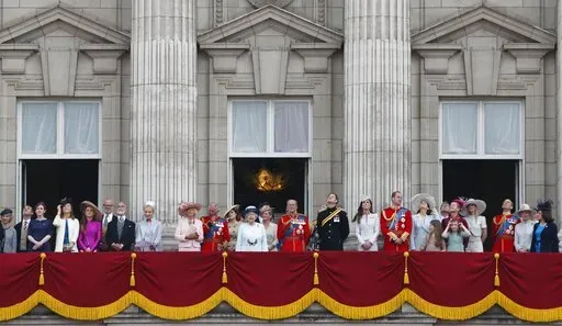 Britain's Queen Elizabeth II, surrounded by members of the family, stand on the balcony of Buckingham Palace to watch the fly past after the Trooping The Colour parade, in central London, Saturday, June 14, 2014. The balcony appearance is the centerpiece of almost all royal celebrations in Britain, a chance for the public to catch a glimpse of the family assembled for a grand photo to mark weddings, coronations and jubilees. (AP Photo/Lefteris Pitarakis, File)