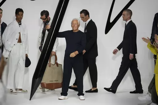Designer Giorgio Armani receives applause at the end of the Giorgio Armani men's Spring Summer 2024 fashion show presented in Milan, Italy, Monday, June 19, 2023. (AP Photo/Luca Bruno)