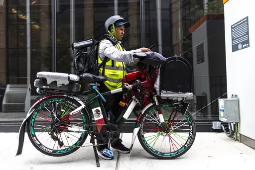 Sergio Solano, an immigrant from Mexico, gets ready for his next delivery, June 21, 2024, in New York. (AP Photo/Eduardo Munoz Alvarez)