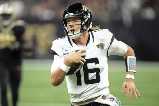 Jacksonville Jaguars quarterback Trevor Lawrence (16) runs for yardage against the New Orleans Saints in the first half of an NFL football game in New Orleans, Thursday, Oct. 19, 2023. (AP Photo/Gerald Herbert)