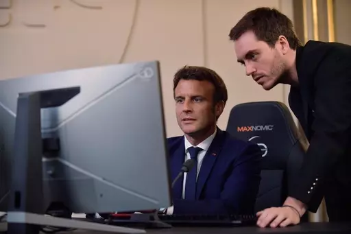French President Emmanuel Macron plays a video game next to Adrien Nougaret, aka ZeratoR, during a meeting with French esport video game players at the Elysee Palace in Paris, Friday June 3, 2022. French President Emmanuel Macron is extending an olive branch to video gamers after previously linking video games to riots that rocked France this year. Posting on the platform previously known as Twitter, Macron backpedalled on remarks where he had blamed video games for having “intoxicated” some