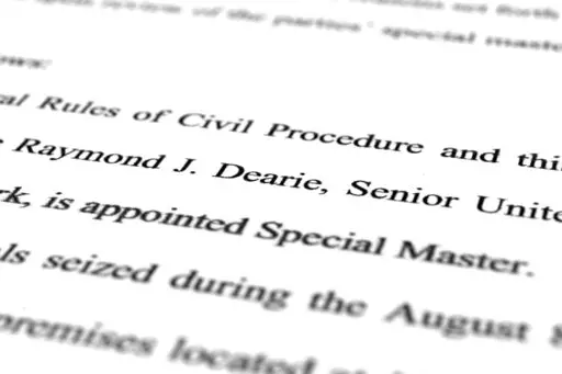 A page from the order by U.S. District Judge Aileen Cannon naming Raymond Dearie as special master to serve as an independent arbiter and to review records seized during the FBI search of former President Donald Trump's Mar-a-Lago estate, is photographed Thursday, Sept. 15, 2022. (AP Photo/Jon Elswick)
