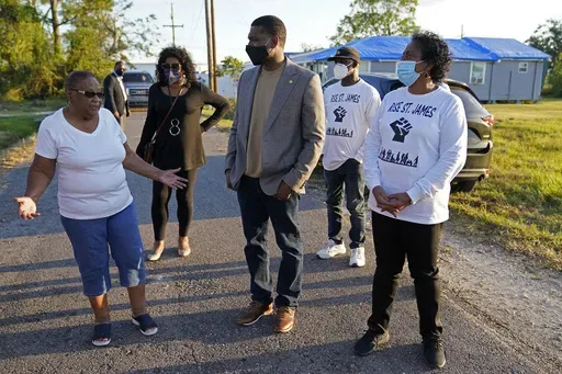 EPA Administrator Michael Regan talks with Brenda Bryant, left, and other members of the group Rise St. James, as he tours a neighborhood next to the Nu Star Energy oil storage tanks, in St. James Parish, La., on Nov. 16, 2021. (AP Photo/Gerald Herbert, File)