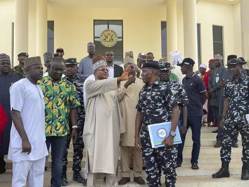 Kaduna state governor Uba Sani, centre, gestures after a meeting with security officers in Kaduna, Nigeria, Sunday, March 24, 2024. Officials in Nigeria say over 130 of nearly 300 schoolchildren have been released more than two weeks after they were seized in the northwestern state of Kaduna and marched into the forests. Sani, who first announced the rescue, did not give details about the operation. (AP Photo/Chinedu Asadu)