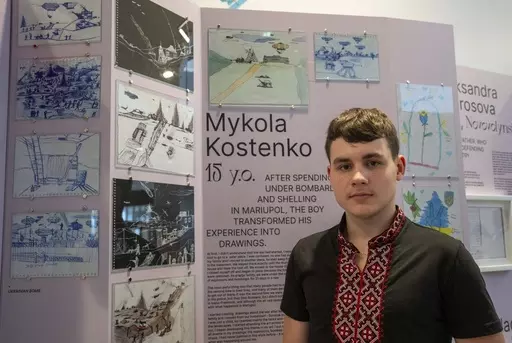 Drawings by Mykola Kostenko, pictured, are part of the War Diaries exhibition, showcasing the personal diaries of Ukrainian children who have witnessed the war, hosted by the Amsterdam city hall , Netherlands, Thursday, Aug. 17, 2023. The city where Anne Frank wrote her World War II diary while hiding with her family from the brutal Nazi occupation is hosting an exhibition with grim echoes of her plight more than three quarters of a century later.(AP Photo/Peter Dejong)