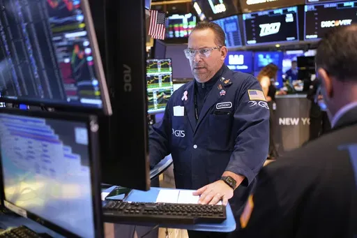People work on the floor at the New York Stock Exchange in New York, Wednesday, March 19, 2025. (AP Photo/Seth Wenig)