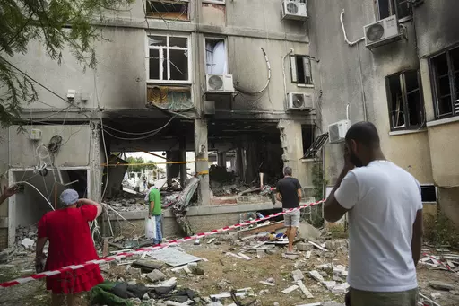 Israelis inspect a damaged residential building after it was hit by a rocket fired from the Gaza Strip, in Ashkelon, Israel, Monday, Oct. 9, 2023. The militant Hamas rulers of the Gaza Strip carried out an unprecedented, multi-front attack on Israel at daybreak Saturday, firing thousands of rockets as dozens of Hamas fighters infiltrated the heavily fortified border in several locations by air, land, and sea, killing hundreds and taking captives. Palestinian health officials reported scores of d
