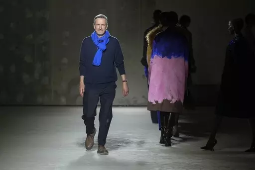 Belgian fashion designer Dries Van Noten accepts applause after his Fall/Winter 2024-2025 ready-to-wear collection presented Wednesday, Feb. 28, 2024 in Paris. Van Noten said Tuesday, March 19, 2024, he will step down from his namesake brand at the end of June. (Scott A Garfitt/Invision/AP, File)