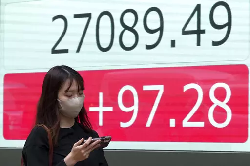 A person walks in front of an electronic stock board showing Japan's Nikkei 225 index at a securities firm Wednesday, Oct. 5, 2022, in Tokyo. Hong Kong’s share benchmark soared more than 5% on Wednesday as Asian shares tracked gains on Wall Street. (AP Photo/Eugene Hoshiko)