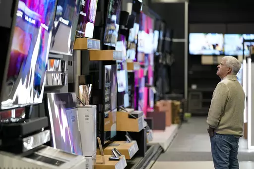 A customer browses televisions at a Best Buy store on Black Friday, Friday, Nov. 24, 2023, in Charlotte, N.C. If you’re planning on grabbing groceries or doing some other shopping this New Year’s Day, it’s wise to double check stores’ hours. (AP Photo/Erik Verduzco, File)