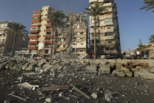 People gather in front of a destroyed building hit in an Israeli airstrike in Tyre, Lebanon, Monday, Oct. 28, 2024.(AP Photo/Mohammed Zaatari)