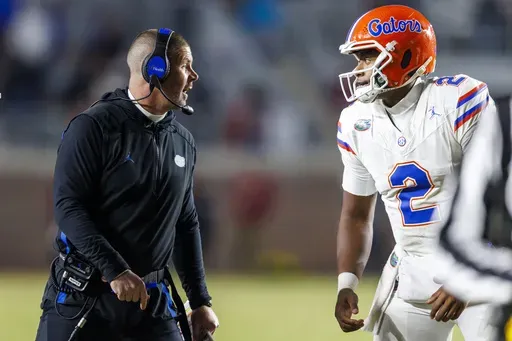 Florida head coach Billy Napier talks with quarterback DJ Lagway (2) during the second half of an NCAA college football game against Florida State Saturday, Nov. 30, 2024, in Tallahassee, Fla. (AP Photo/Colin Hackley)