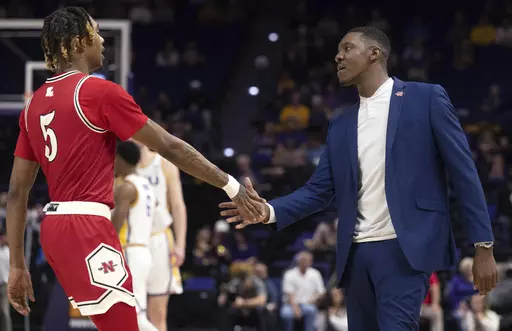 Nicholls forward Diante Smith (5) reaches out to coach Tevon Saddler as Smith heads to the bench during the team's NCAA college basketball game against LSU on Friday, Nov. 10, 2023, in Baton Rouge, La. (Hilary Scheinuk/The Advocate via AP)