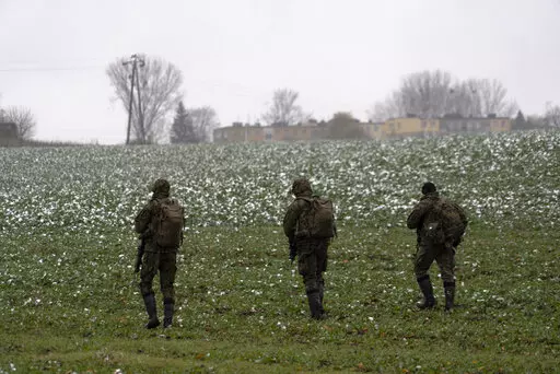 Polish soldiers search for missile wreckage in the field, near the place where a missile struck, in a farmland at the Polish village of Przewodow, near the border with Ukraine, Thursday, Nov. 17, 2022. (AP Photo/Vasilisa Stepanenko)