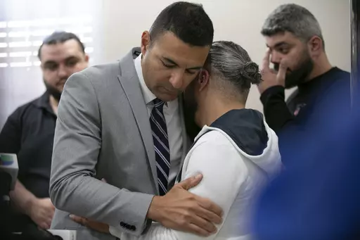 Ahmed Rehab, left, executive director of the Chicago chapter of the Council on American-Islamic Relations, embraces Odey Al-Fayoume, father of Wadea Al-Fayoume, 6, at a news conference at the Muslim Community Center on Chicago's Northwest Side, Sunday, Oct. 15, 2023. Authorities say a 71-year-old Illinois man has been charged with a hate crime, accused of fatally stabbing a 6-year-old boy and seriously wounding a 32-year-old woman, in Plainfield Township, because of their Islamic faith and the I