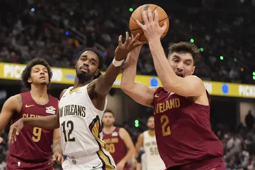 Cleveland Cavaliers guard Ty Jerome (2) takes the ball from New Orleans Pelicans guard Antonio Reeves (12) in the first half of an NBA basketball game, Wednesday, Nov. 20, 2024, in Cleveland. (AP Photo/Sue Ogrocki)