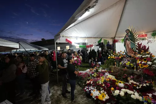 Devotees pray in front of a figure of the Virgin of Guadalupe during a festival celebrating one of several apparitions of the Virgin Mary witnessed by an indigenous Mexican man named Juan Diego in 1531, at St. Ann Mission in Naranja, Fla., Sunday, Dec. 10, 2023. For this mission church where Miami's urban sprawl fades into farmland and the Everglades swampy wilderness, it's the most important event of the year, both culturally and to fundraise to continue to minister to the migrant farmworkers i