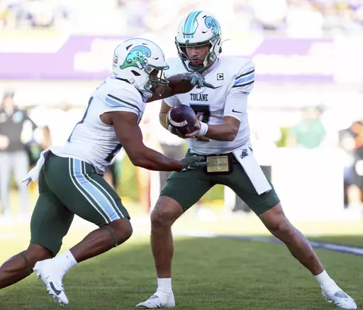 Tulane's Michael Pratt (7) hands the ball off to Makhi Hughes, left, during an NCAA college football game against East Carolina on Saturday, Nov. 4, 2023, in Greenville N.C. (Scott Davis/News & Record via AP)