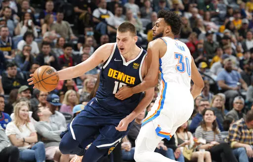 Denver Nuggets center Nikola Jokic, left, drives past Oklahoma City Thunder center Olivier Sarr in the second half of an NBA basketball game Saturday, March 26, 2022, in Denver. (AP Photo/David Zalubowski)