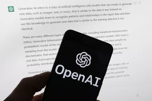 The OpenAI logo is seen on a mobile phone in front of a computer screen displaying output from ChatGPT, Tuesday, March 21, 2023, in Boston. Are tech companies moving too fast in rolling out powerful artificial intelligence technology that could one day outsmart humans? That is the conclusion of a group of prominent computer scientists and other tech industry notables who are calling for a 6-month pause to consider the risks. Their petition published Wednesday, March 29, 2023, is a response to Sa