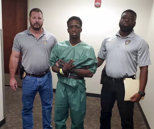 This photo provided by Baton Rouge Police Department shows suspect Earl Lee Johnson, center, who was arrested on a charge of first-degree murder on Tuesday, April 19, 2022, in Baton Rouge, La. A livestreamed fatal stabbing of a woman, Janice David, on social media led police to her body in an office building parking lot in Louisiana's capital. During a news conference Tuesday to announce the arrest, police said Johnson and David had been on a dayslong “drug binge” before he allegedly choked,