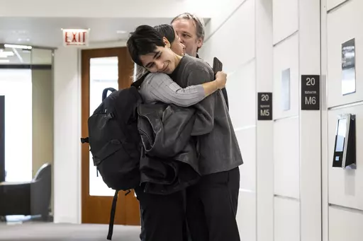 Lucia Morales hugs her 19-year-old son, Rylan Wilder in the hallway at their attorney's office in the Loop, Wednesday, Oct. 18, 2023. Wilder, who was shot and wounded during a 2019 shootout between suburban Chicago police and a bank robbery suspect inside a music school has reached a $1.9 million settlement with the city of Des Plaines. (Ashlee Rezin /Chicago Sun-Times via AP)