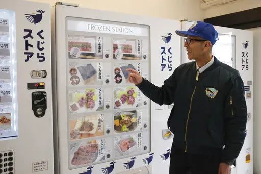 Konomu Kubo, a spokesperson for Kyodo Senpaku Co. explains how whale meat is being sold from a vending machine at the firm's store, Thursday, Jan. 26, 2023, in Yokohama, Japan. The Japanese whaling operator, after struggling for years to promote its controversial products, has found a new way to cultivate clientele and bolster sales: whale meat vending machines. (AP Photo/Ha Kwyeon)
