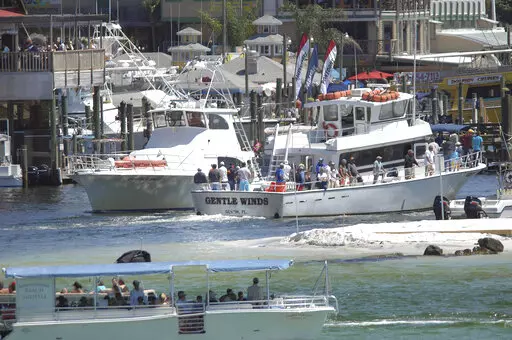In a Friday April 6, 2012 photo, charter fishing boats go in and out of Destin Harbor in Destin, Fla. An appeals court has struck down a federal fisheries management rule requiring operators of privately owned charter boats to equip their vessels with tracking devices, a victory for a group of Louisiana and Florida charter operators who challenged the rule in a 2020 lawsuit. (Nick Tomecek/Northwest Florida Daily News via AP)