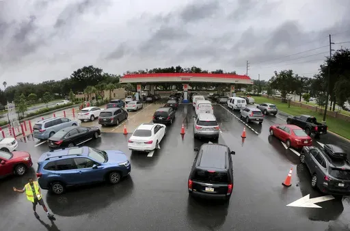 Cars wait in line to get into the parking lot for gas at Costco, Monday, Oct. 7, 2024, in Altamonte Springs, Fla., as residents prepare for the impact of approaching Hurricane Milton. (Joe Burbank/Orlando Sentinel via AP)