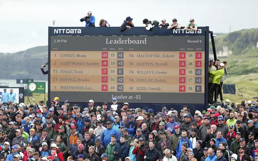 Spectators clamber on to and on top of a scoreboard as they vie to get a glimpse of Ireland's Shane Lowry and England's Tommy Fleetwood as they play during the final round of the British Open Golf Championships at Royal Portrush in Northern Ireland, Sunday, July 21, 2019.  The 150th edition of the British Open is expected to attract a record-breaking crowd of 290,000 when St. Andrews hosts in July, 2022. Organizers say they received more than 1.3 million ticket applications, leading to the highe
