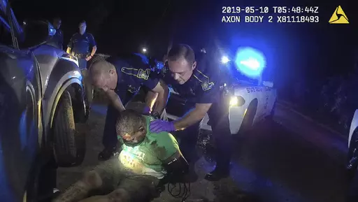 This image from the body camera of Louisiana State Police Trooper Dakota DeMoss shows his colleagues, Kory York, center left, and Chris Hollingsworth, center right, holding up Ronald Greene before paramedics arrived on May 10, 2019, outside of Monroe, La. In July 2023, a state judge has thrown out obstruction of justice charges against DeMoss and York, two of the five Louisiana lawmen indicted in the fatal arrest of Greene. Authorities initially blamed his death on a car crash before long suppre