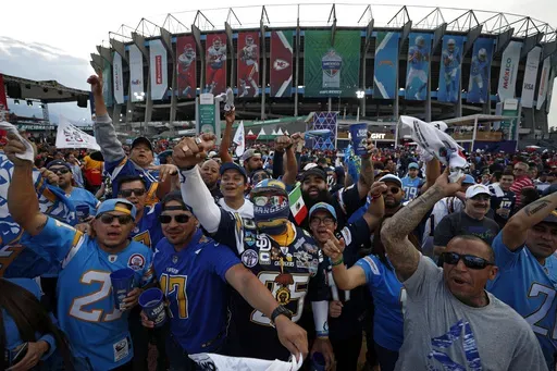 Fans cheer before an NFL football game between the Los Angeles Chargers and the Kansas City Chiefs, Monday, Nov. 18, 2019, outside Azteca stadium in Mexico City. (AP Photo/Rebecca Blackwell, File)