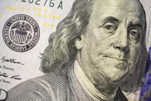 The likeness of Benjamin Franklin is seen on a U.S. $100 bill, Wednesday, Feb. 22, 2023, in Marple Township, Pa. If you are concerned you may be laid off, start saving. It's crucial to start building an emergency fund even when you feel secure at your job but especially if you think you might lose it. (AP Photo/Matt Slocum)