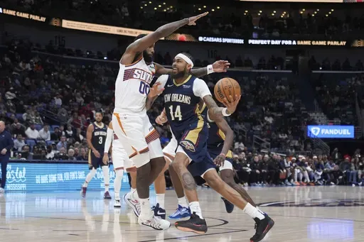 New Orleans Pelicans forward Brandon Ingram (14) drives to the basket against Phoenix Suns forward Royce O'Neale (00) in the second half of an NBA basketball game in New Orleans, Thursday, Dec. 5, 2024. The Pelicans won 126-124. (AP Photo/Gerald Herbert)