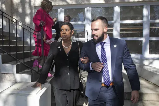 Tessie Prevost-Williams is escorted by U.S. Marshal Michael Atkins, as Gail Etienne, back left, is escorted by U.S. Marshal Brian Fair down the steps of McDonogh 19 Elementary School during the "New Orleans 4" Day 61st anniversary ceremony in New Orleans, Sunday, Nov. 14, 2021. Prevost and Etienne are two of four women who were the first African Americans to integrate the all-white public schools in New Orleans. Prevost-Williams, known as one of the “New Orleans 4,” died July 6 following a s