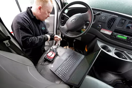 Brian Hohmann, mechanic and owner of Accurate Automotive, in Burlington, Mass., attaches a diagnostics scan tool, center left, to a vehicle and a laptop computer, below, Tuesday, Feb. 1, 2022, in Burlington, Mass. The diagnostics scan tool sends information from the vehicle's computer to the laptop so a mechanic can view information about the vehicle's performance. Hohmann said most independent shops are perfectly capable of competing with dealerships on both repair skills and price as long as t